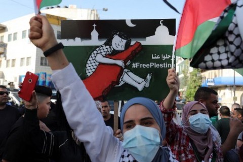 Warga Palestina mendukung rekannya di Gaza yang digempur oleh serangan udara Israel./AFP
