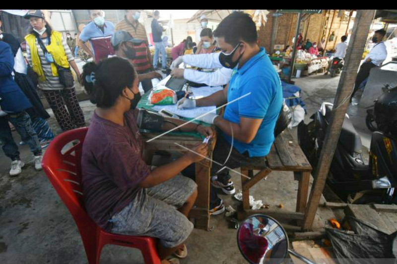 Petugas memeriksa kondisi kesehatan peserta vaksinasi covid-19 di Pasar Tradisional Masomba di Palu, Sulawesi Tengah, Selasa, 17 Agustus 2021. ANTARA FOTO/ Mohamad Hamzah
