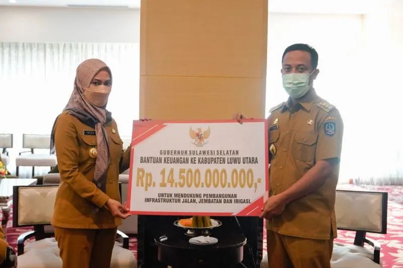 Gubernur Sulsel Andi Sudirman Sulaiman menyerahkan bantuan anggarannya pembangunan sebesar Rp14,5 miliar kepada Bupati Luwu Utara di Makassar, Senin, 6 Juni 2022. Foto: Antara/HO-Pemprov Sulsel