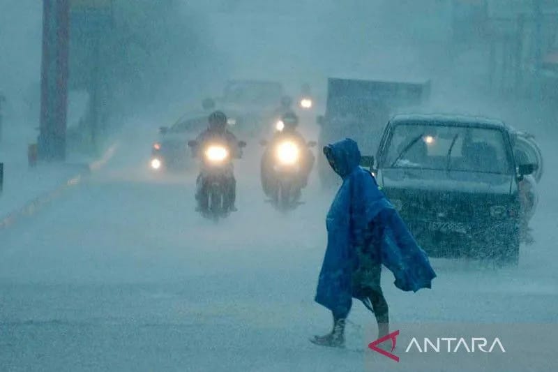 Ilustrasi- Seorang warga melintas diantara pengendara bermotor yang melintasi jalan Laksda Adisucipto saat terjadi hujan yang lebat di Yogyakarta. ANTARA FOTO/ Wahyu Putro A/ed/nz/aa. (FOTO ANTARA Wahyu Putro A/ed/nz.)