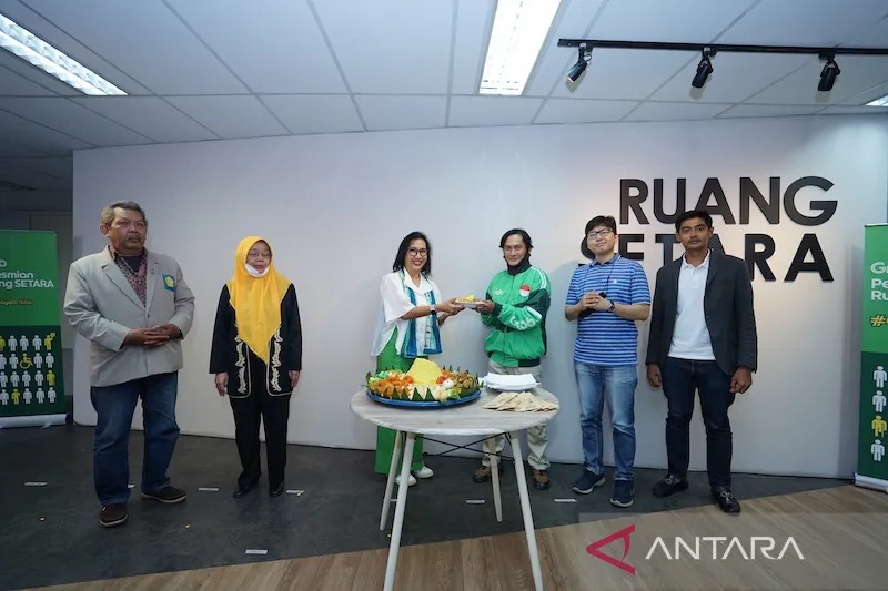 Country Managing Director Grab Indonesia Neneng Goenadi (ketiga kiri) menyerahkan potongan tumpeng kepada perwakilan Mitra Pengemudi Disabilitas Wicara Grab Oni Maulana (ketiga kanan) dalam rangka peresmian Ruang SETARA di Jakarta (22/09). Prosesi ini tur