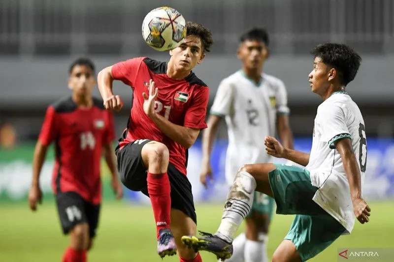 esepak bola Tim Nasional U-17 Indonesia Mokhamad Hanif Ramadhan (kanan) berebut bola dengan pesepak bola Tim Nasional U-17 Palestina Ahmed Sulaiman (kiri) dalam laga Grup B Kualifikasi Piala Asia U-17 2023 di Stadion Pakansari, Cibinong, Kabupaten Bogor, 