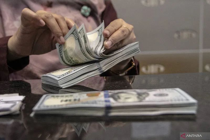 Petugas menghitung uang pecahan dolar AS di gerai penukaran mata uang asing VIP (Valuta Inti Prima) Money Changer, Jakarta, Selasa (4/10/2022). ANTARA FOTO/Muhammad Adimaja/aww.