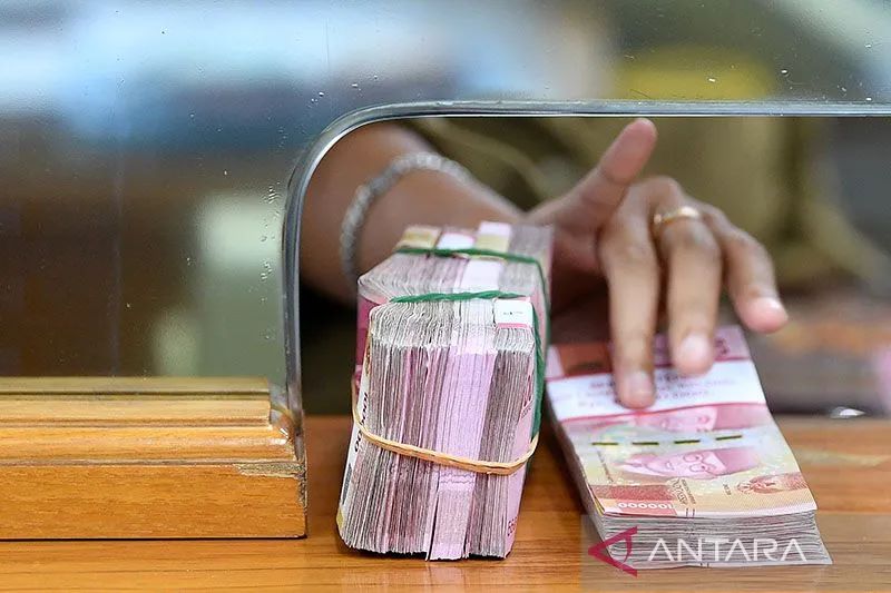 Ilustrasi: Karyawan memegang mata uang rupiah di gerai penukaran mata uang asing Ayu Masagung, Kwitang, Jakarta Pusat. ANTARA FOTO/Sigid Kurniawan/aww. (ANTARA FOTO/SIGID KURNIAWAN)