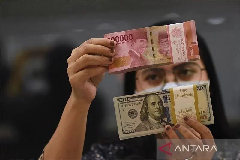 Pegawai menunjukkan mata uang rupiah dan dolar AS di salah satu gerai penukaran mata uang di Jakarta. ANTARA FOTO/Indrianto Eko Suwarso/YU/aa.