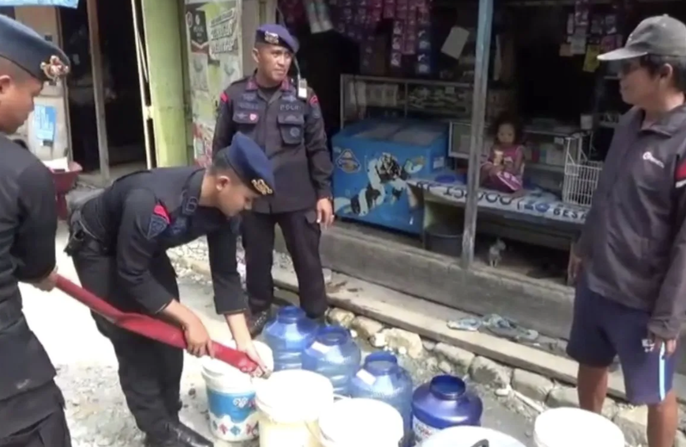 Personel Batalyon C Pelopor Sat Brimob Polda Sultra saat menyalurkan air bersih di Desa Wawo, Kecamatan Wawo, Kabupaten Kolaka Utara. (Antara/HO-Sat Brimob Polda Sultra)